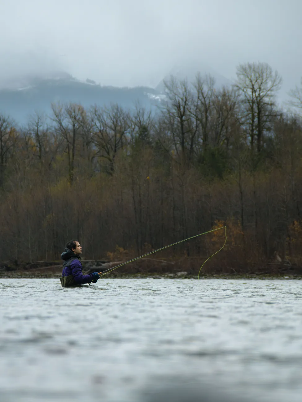 Pêche à la mouche dans une rivière boisée